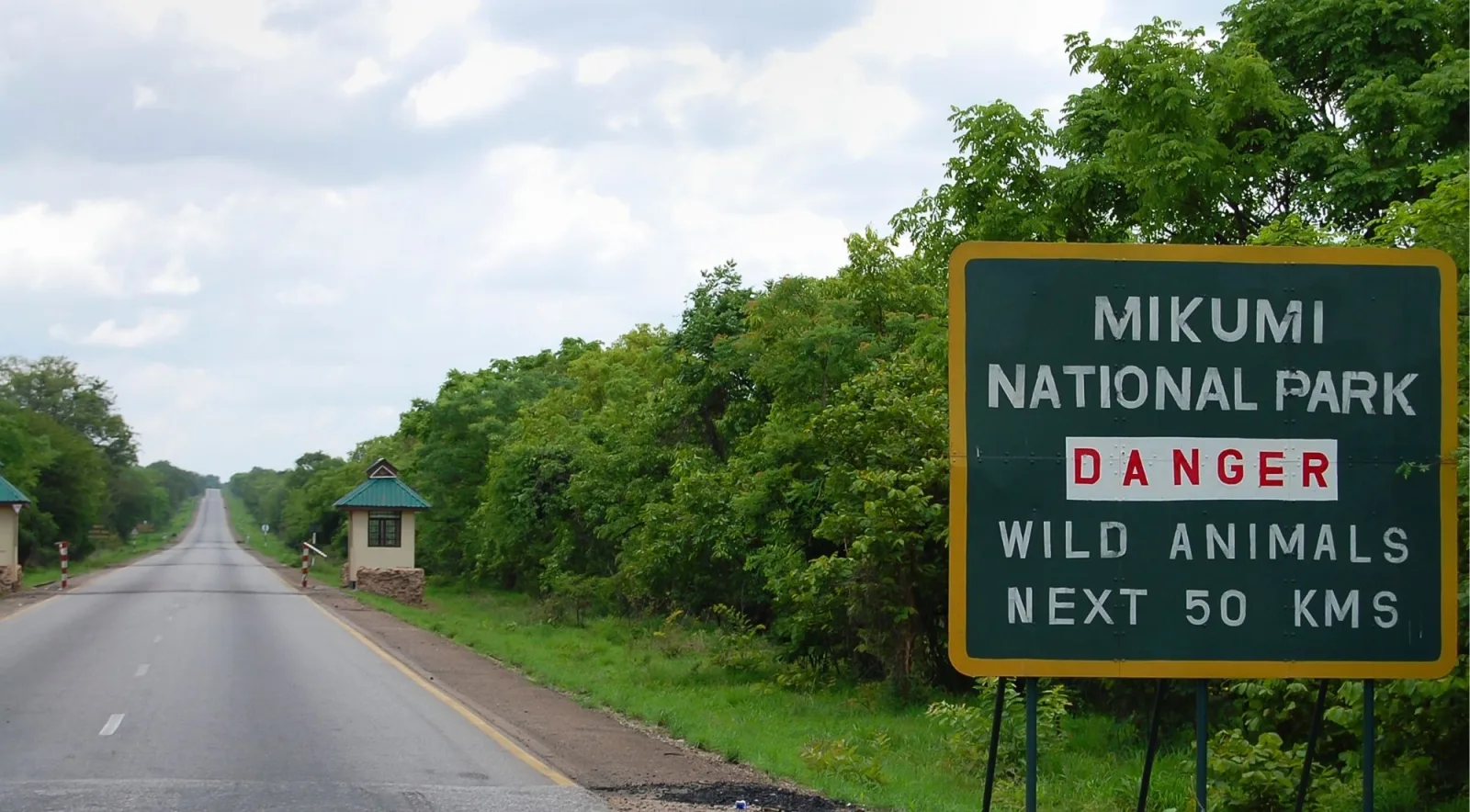 Mikumi National Park entrance sign on the Tanzam Highway reading DANGER WILD ANIMALS NEXT 50 KMS